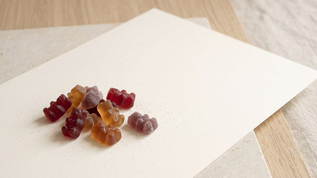 Fruchtgummis auf Pektin-Basis mit Zuckerkristallen auf hellem Papier